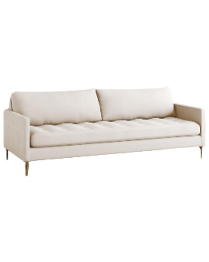 Sillón Ristretto de dos cuerpos con respaldo de almohadones sueltos, asiento tapizado capitoné y patas finas metálicas doradas. Diseño moderno y elegante con detalles clásicos.