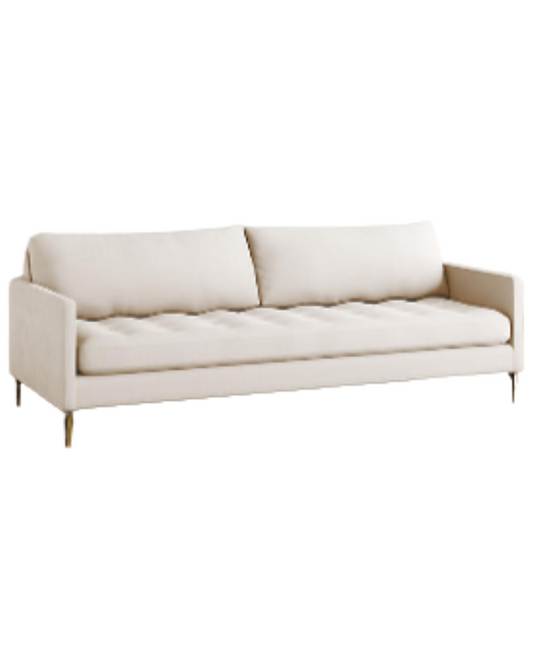 Sillón Ristretto de dos cuerpos con respaldo de almohadones sueltos, asiento tapizado capitoné y patas finas metálicas doradas. Diseño moderno y elegante con detalles clásicos.