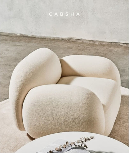 Detalle del tapizado boucle y la estructura de madera maciza del sillón Cabsha - Tienda de Banquitos