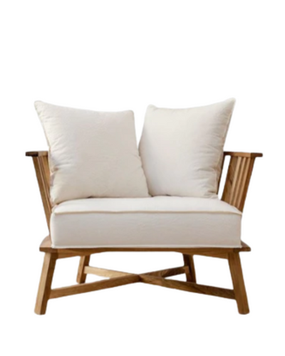 Sillón individual de estructura de madera clara con brazos y respaldo de listones, cojines blancos sueltos en asiento y respaldo, de diseño minimalista y estilo escandinavo.