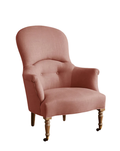 Sillón individual de diseño tradicional en tono rosa viejo, con respaldo curvo, apoyabrazos tallados y patas delanteras de madera con ruedas.
