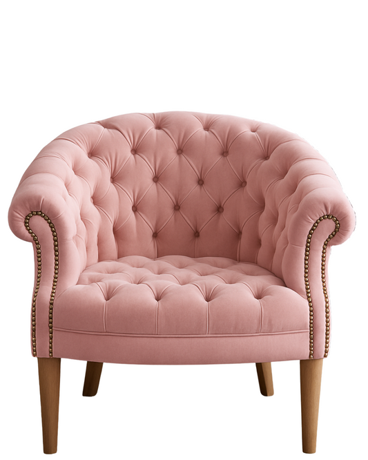 Sillón individual tapizado en rosa claro, con respaldo y asiento redondeados totalmente capitoné, brazos curvos integrados y patas de madera claras.