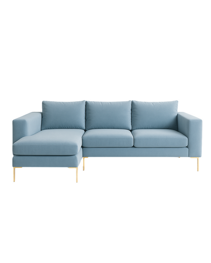 Sillón esquinero moderno en azul celeste con patas doradas, líneas limpias y almohadones sueltos. Estilo nórdico con toque glam.