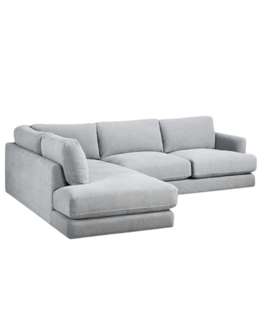 Sillón esquinero amplio en gris claro, almohadones grandes y asiento profundo. Confort máximo en estilo contemporáneo.