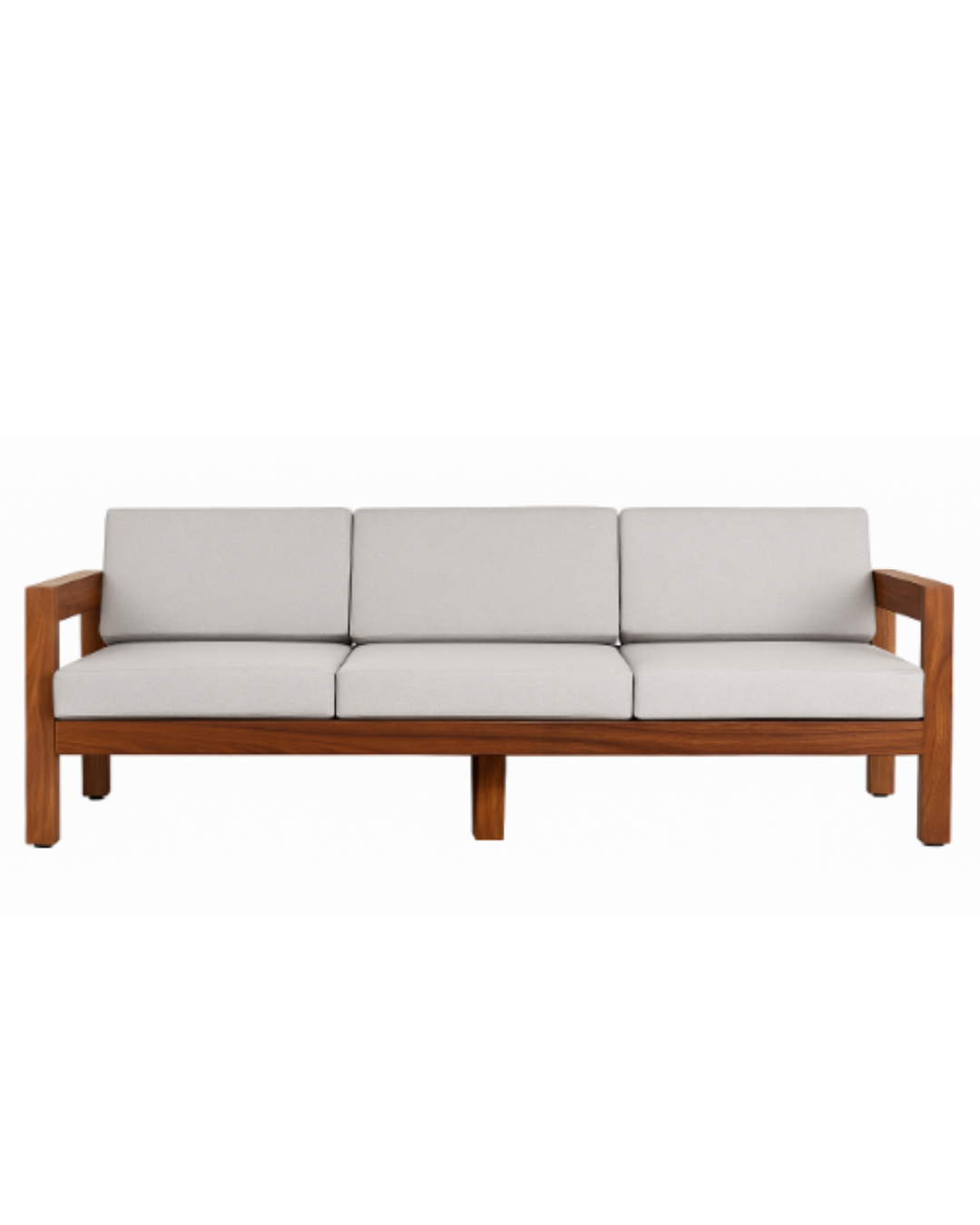 Fotografía editorial de un living elegante con un gran ventanal abierto hacia un patio con plantas. En el interior, destaca un sillón de tres cuerpos con estructura de madera noble y almohadones gris claro, acompañado por una mesa ratona redonda, una alfombra con texturas y un sillón individual de cuero.