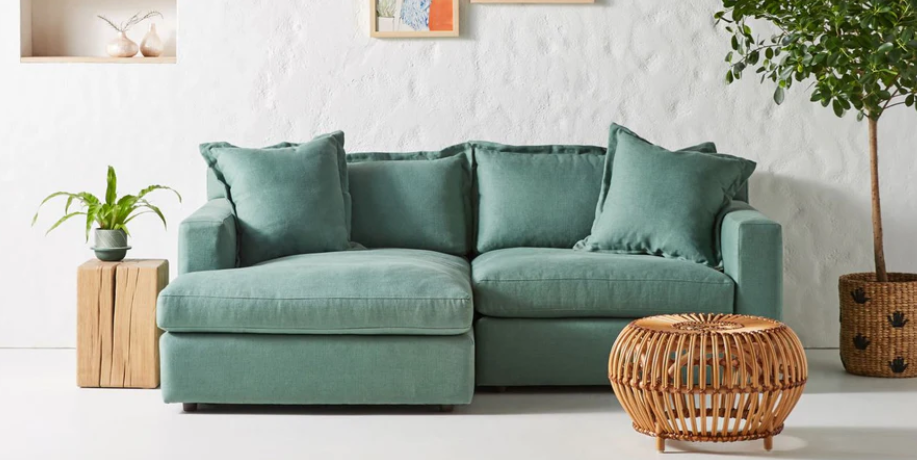 Sofá esquinero Enrique en color celeste verdoso con cojines estructurados y respaldo cómodo; oferta CyberMonday con descuentos y cuotas sin interés por tiempo limitado.

