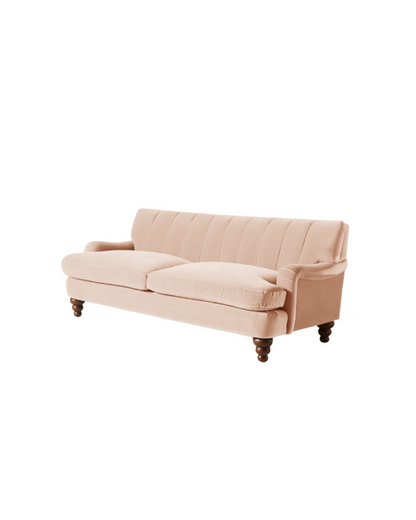 Vista completa del sofá modelo Malaika tapizado con respaldo vainillado profundo, brazos curvos y elegantes patas de madera oscura torneada, ubicado sobre fondo blanco, ideal para salas de estar, livings modernos o espacios clásicos que buscan un mueble llamativo y sofisticado.