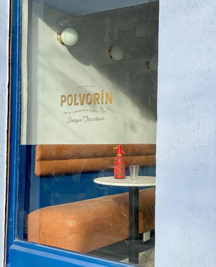 Banco corrido en tono suela junto a la vidriera de Polvorín, café de especialidad en Parque Chacabuco