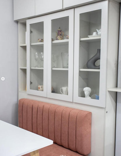 Banco a medida con respaldo de canales verticales en terracota, junto a un mueble vitrina blanco, en un proyecto con WN Interiores