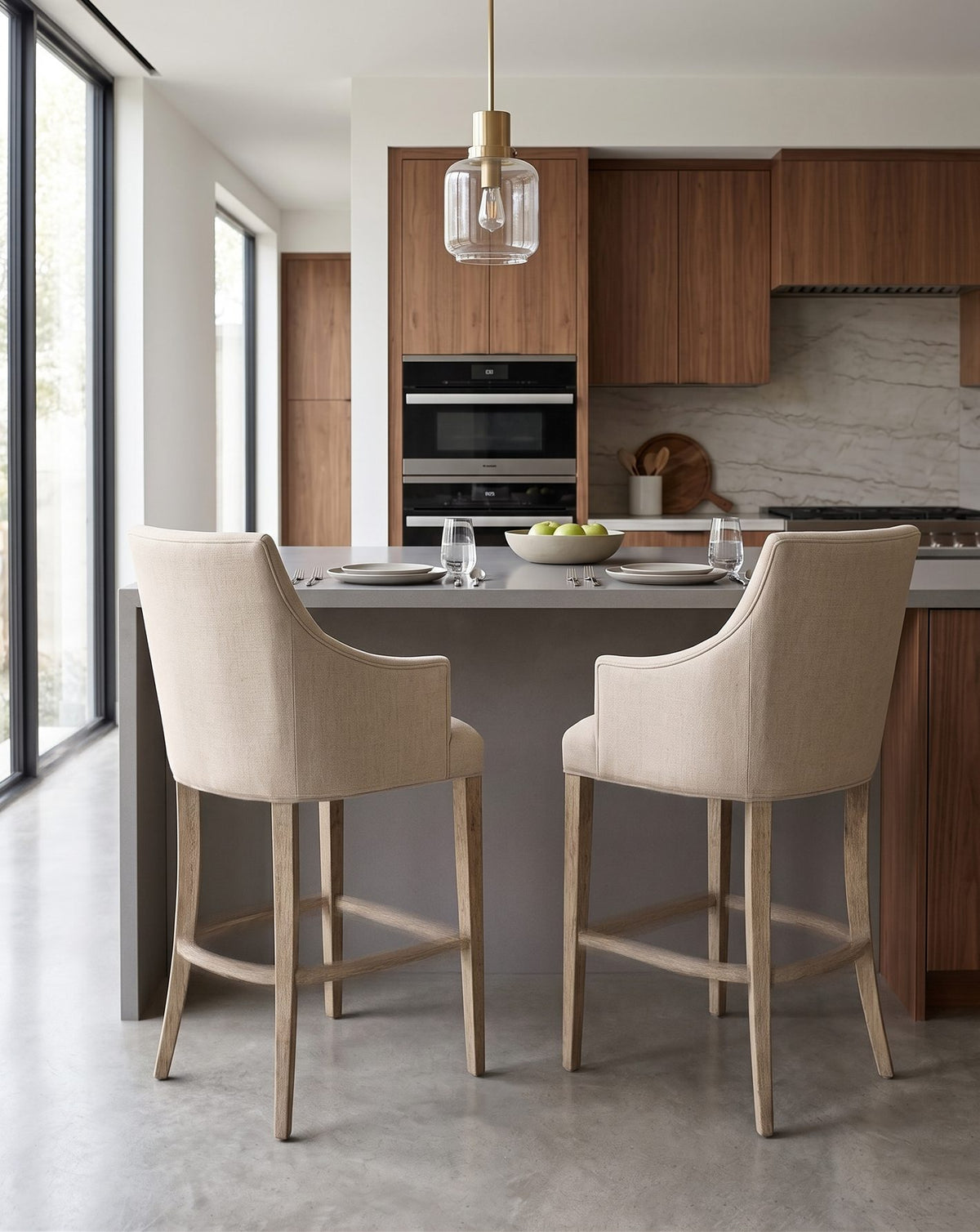 Dos Banquetas Altas Guillermina crema en una cocina con muebles de madera y lámpara colgante