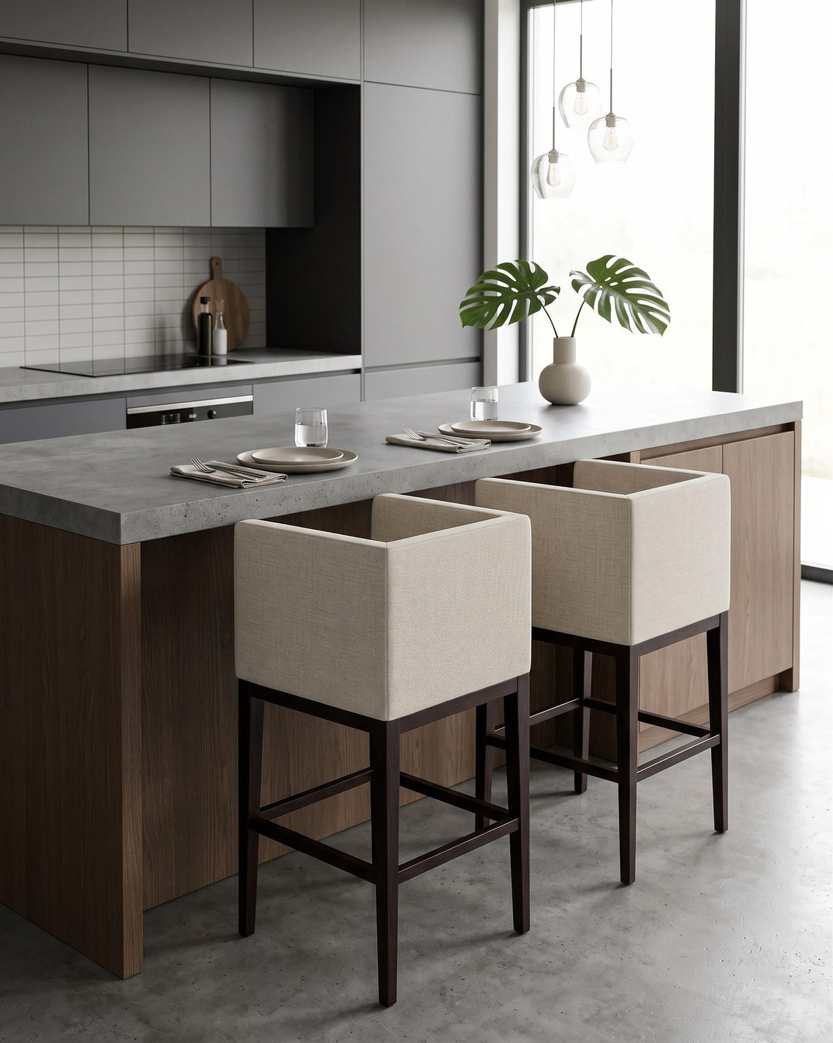 Dos Banquetas Altas Pitanga crema junto a una isla de cocina gris con plantas