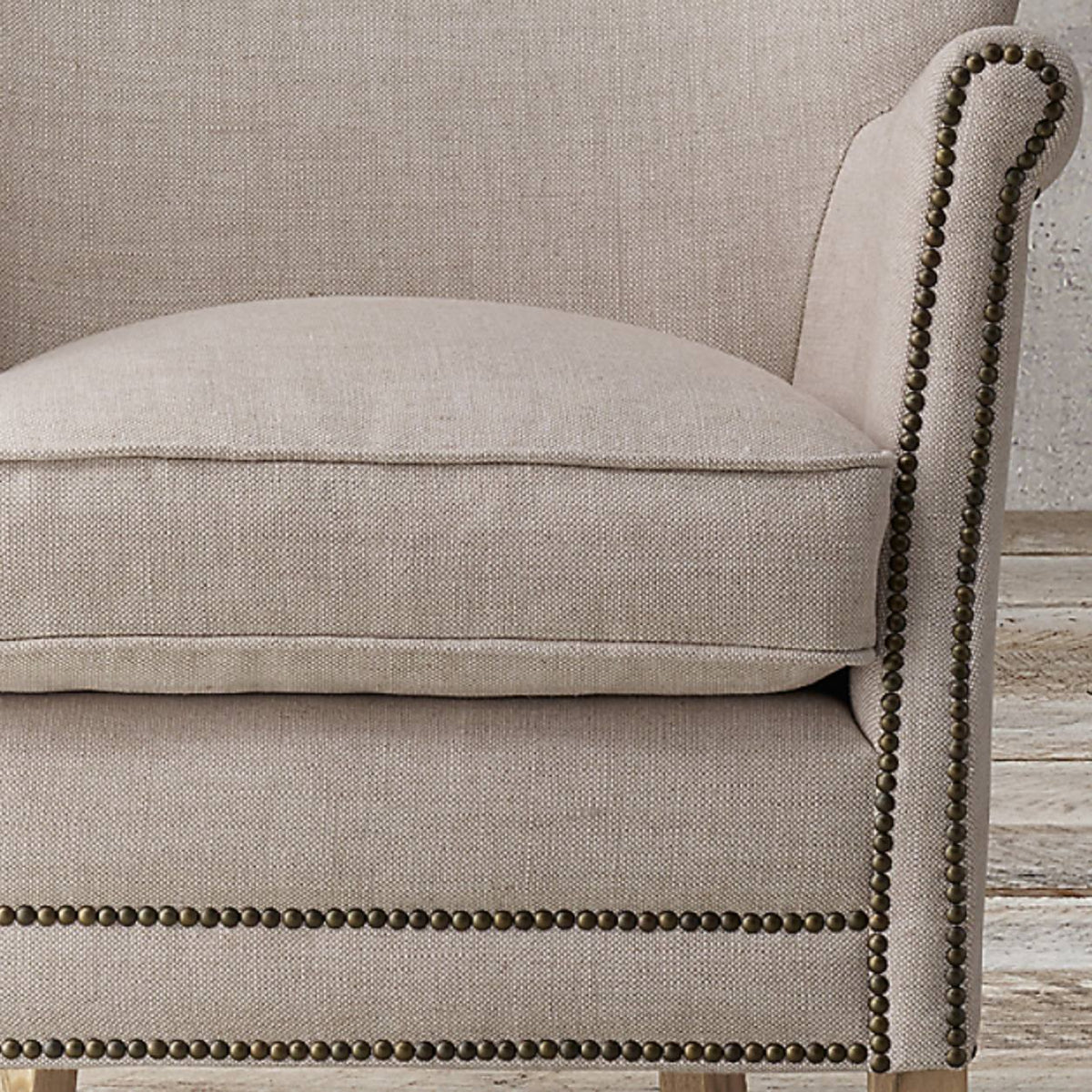 Detalle del almohadón de asiento y las tachas del brazo de la Banqueta Valquiria beige