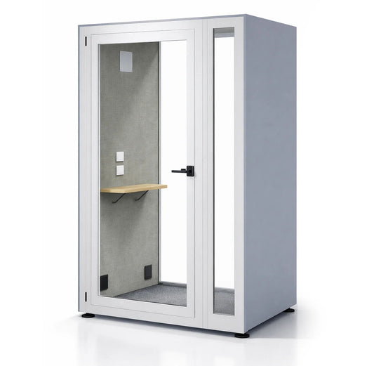 Cabina acústica Prisma M de Archivos Activos, exterior gris azulado con marco blanco, puerta y paño lateral de vidrio