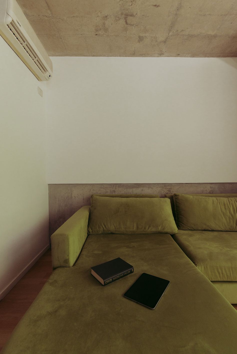 Chaise del Sillón Esquinero Richard verde con dos libros apoyados, en el loft de Santiago Colinet