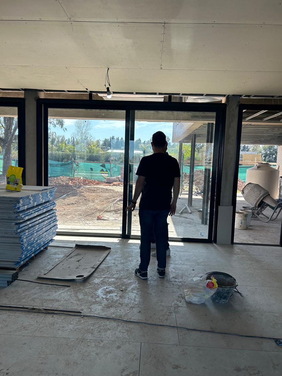 Ventanales del salón del Club House del Country Área 60 en obra, con vista al parque