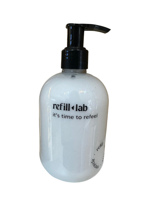 Frasco de Crema Corporal Refill Lab de 300 ml con válvula negra y crema blanca, sobre fondo negro