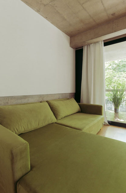 Detalle del chaise y los almohadones del Sillón Esquinero Richard de terciopelo verde