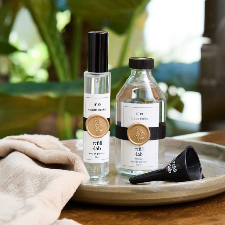 Frasco de 50 ml y recarga de 250 ml de Árabe Tonka Refill Lab sobre una bandeja con embudo