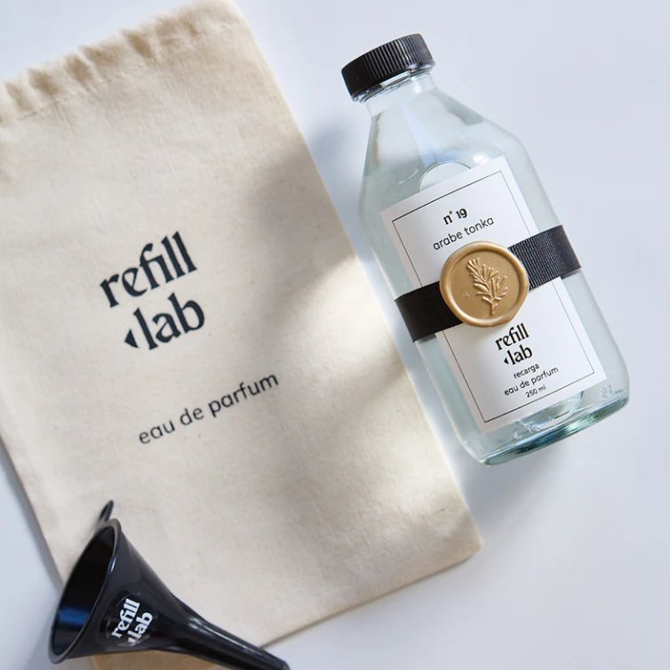 Recarga de 250 ml de Árabe Tonka Refill Lab junto a su bolsa de tela y un embudo negro