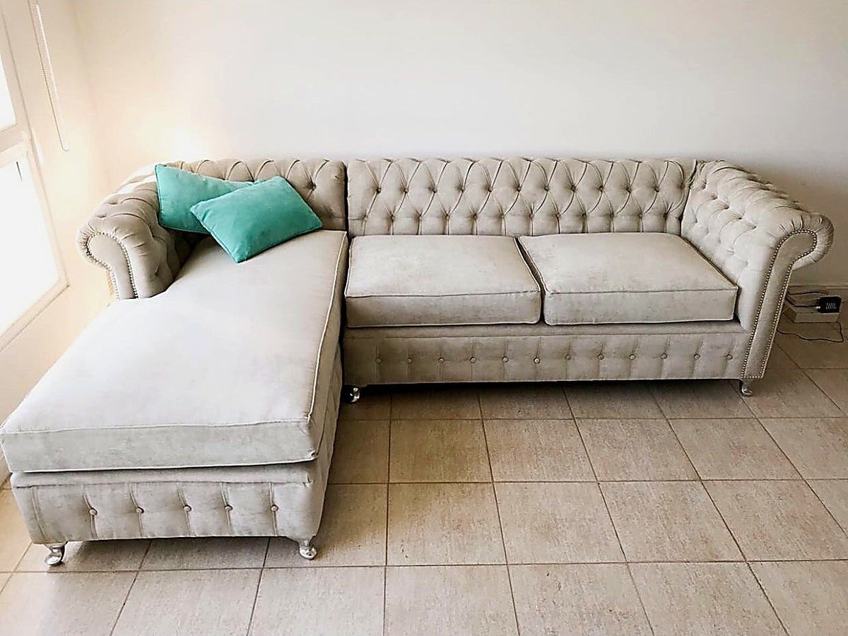 Esquinero Chesterfield beige con capitoné, tachas plateadas y chaise a la izquierda, en el living de María Martha