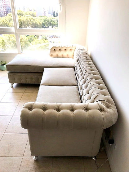 Respaldo capitoné del Esquinero Chesterfield beige de María Martha, junto al ventanal del living