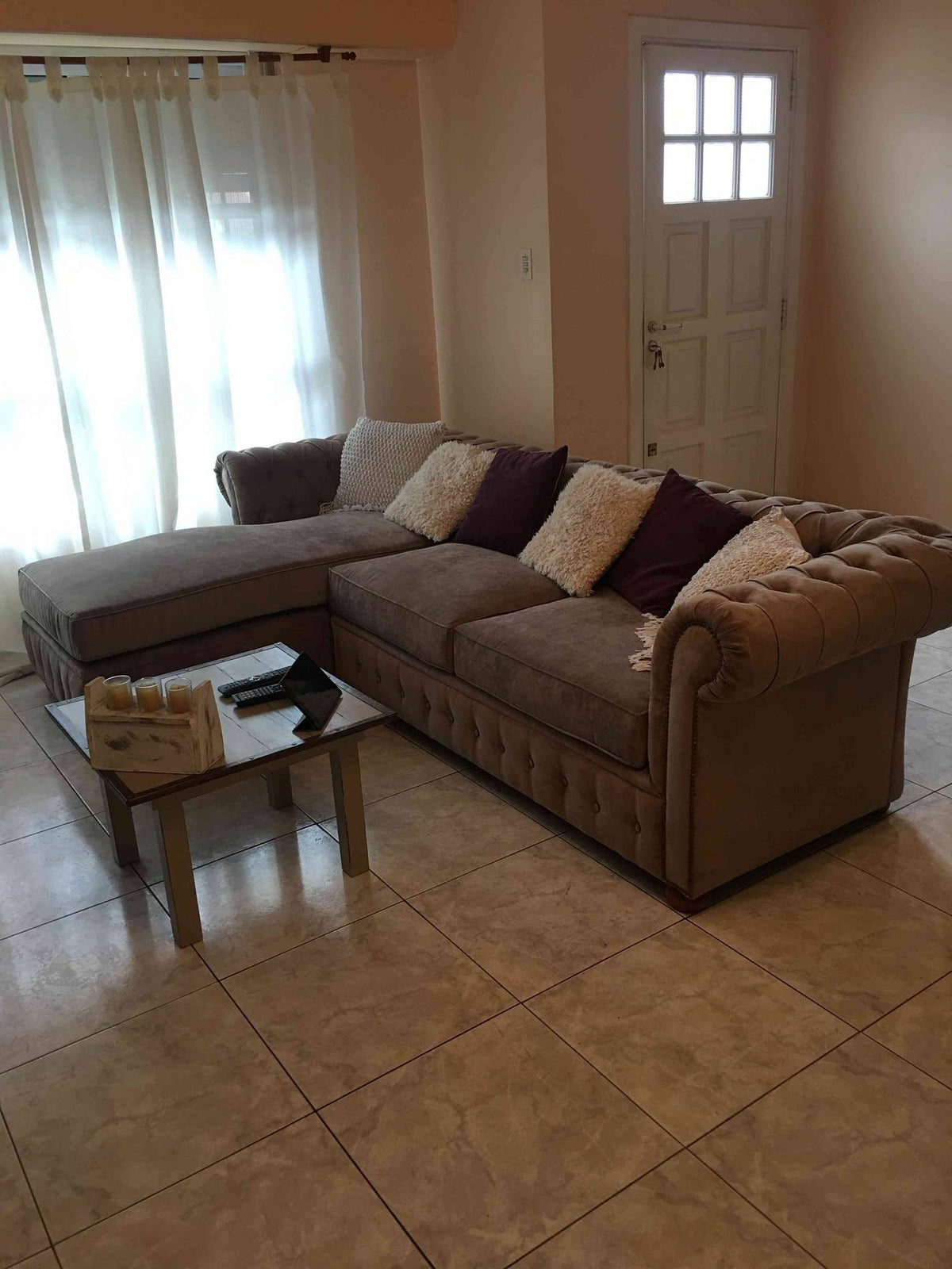Vista general del Esquinero Chesterfield beige de Micaela, con el chaise a la izquierda y la mesa ratona de vidrio