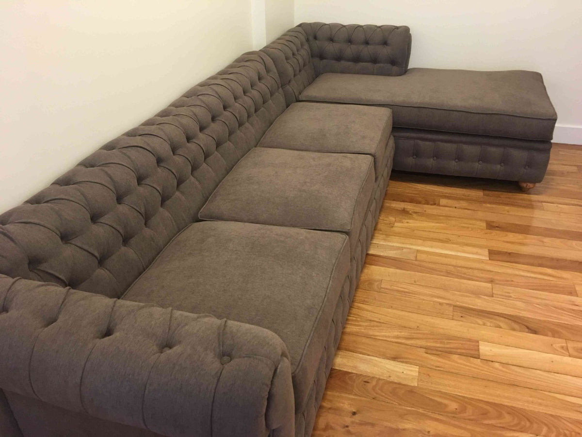 Esquinero Chesterfield gris marrón con chaise, visto desde el frente en el living de Nora