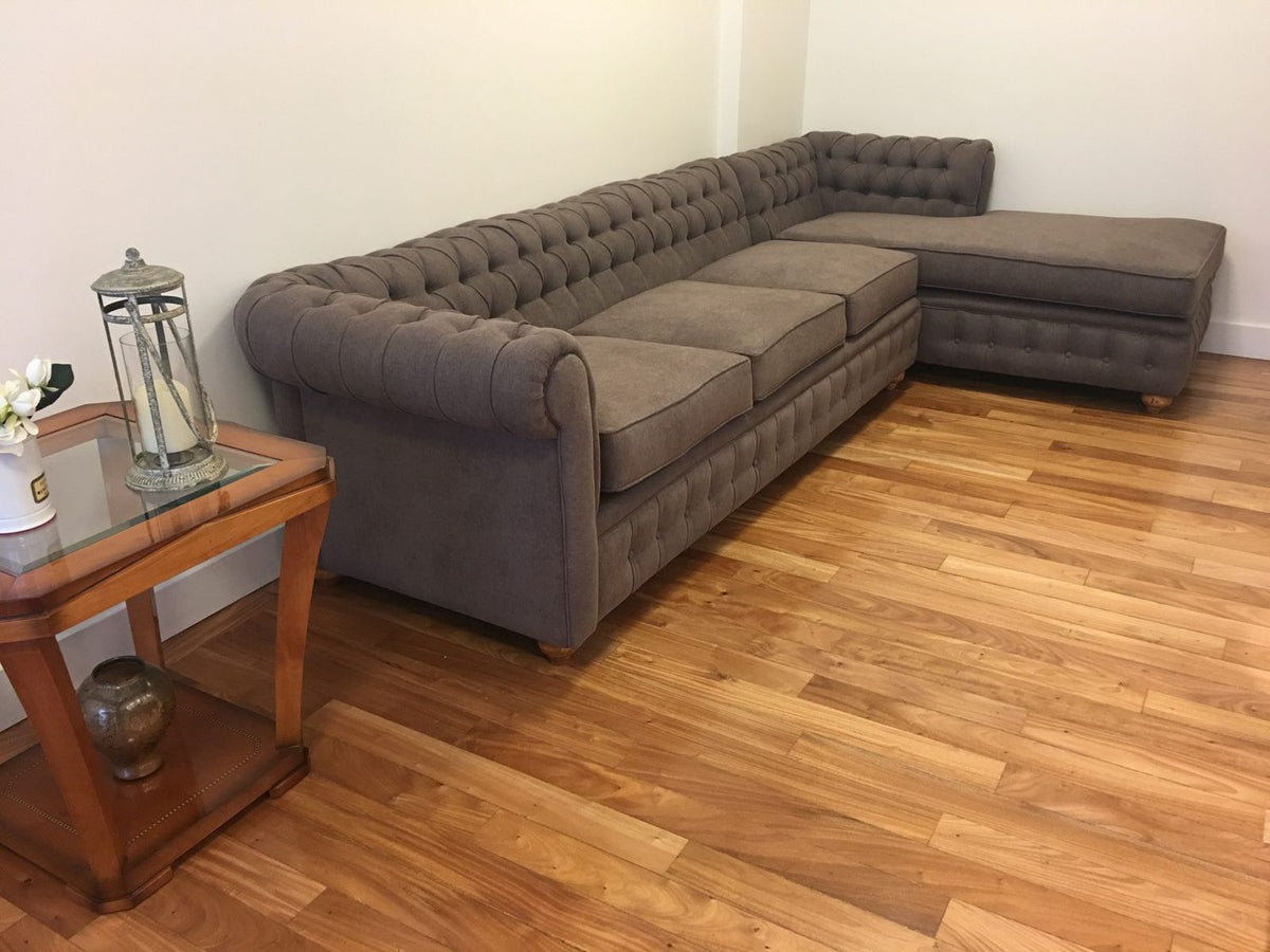 Vista lateral del Esquinero Chesterfield gris marrón de Nora, con las patas torneadas a la vista