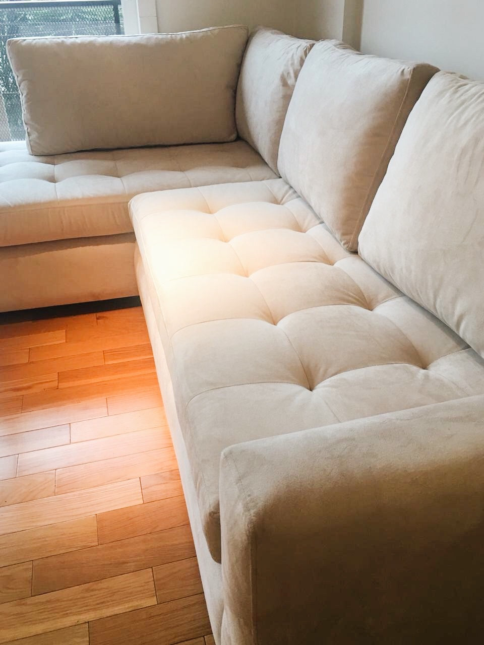 Detalle del asiento capitoné del esquinero crema de Nerina
