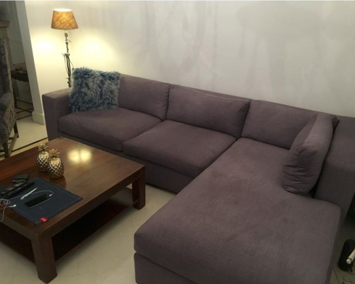 Esquinero Elton en gris malva con chaise longue y almohadón de piel, junto a la lámpara de pie del living de Lucrecia en Castelar
