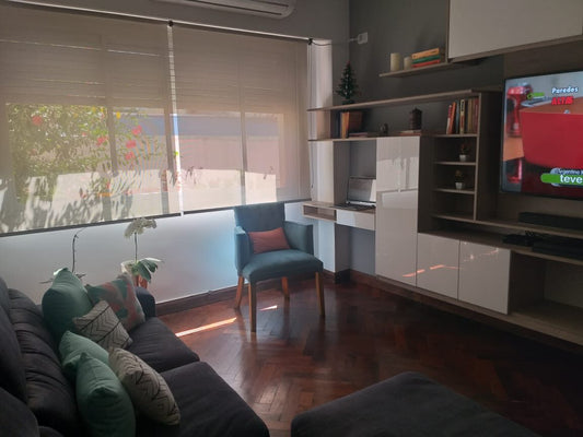 Esquinero Enrique en antracita con almohadones teal y Butaca Esther en verde petróleo, en el living con parquet espiga de Milagros