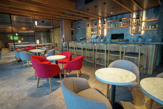 Bar del Hampton by Hilton Bariloche con los sillones rojos y grises fabricados por Tienda de Banquitos