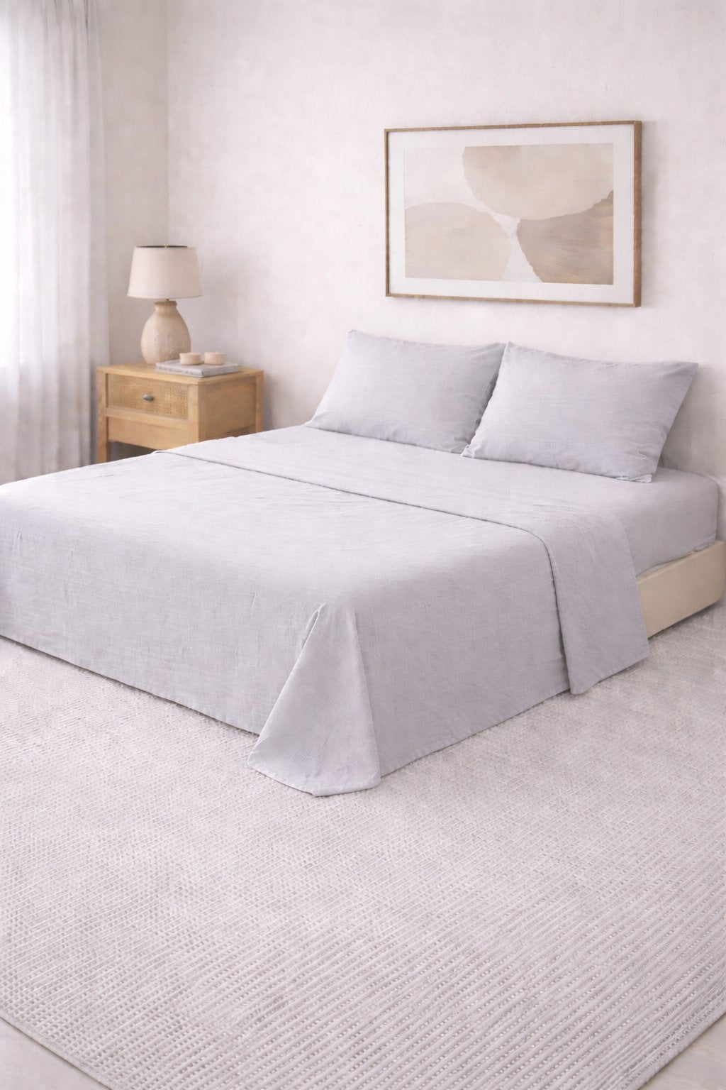 Juego de sábanas lisas Queen gris claro con dos fundas de almohada, en dormitorio con mesa de luz de madera