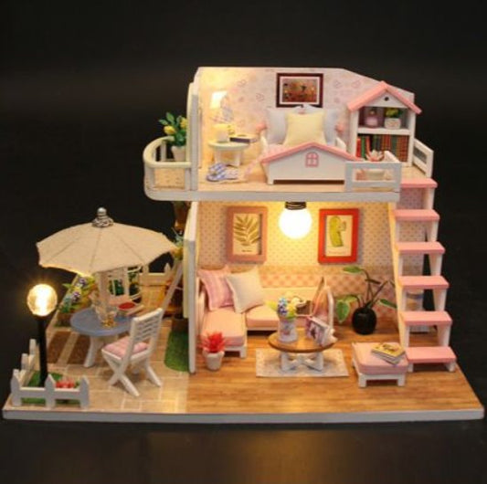 Loft rosa en miniatura de dos niveles, con cama arriba, escalera, living, patio con sombrilla y luces