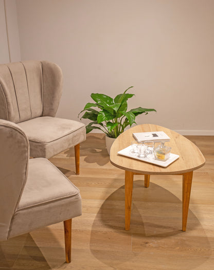 Dos butacas tapizadas en tela beige con respaldo alto y diseño con costuras verticales, apoyadas sobre patas de madera clara