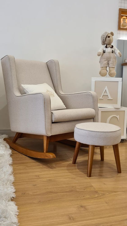 Mecedora Ciruelo en beige con un almohadón blanco, junto a un puff y cubos con letras en un cuarto infantil