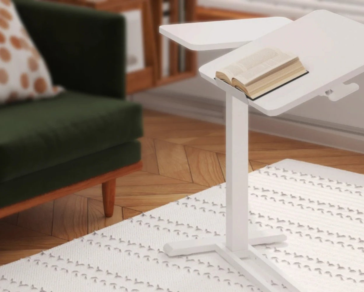 Mesa de arrime Lumiere de Archivos Activos blanca con la tapa inclinada junto a un sofá verde