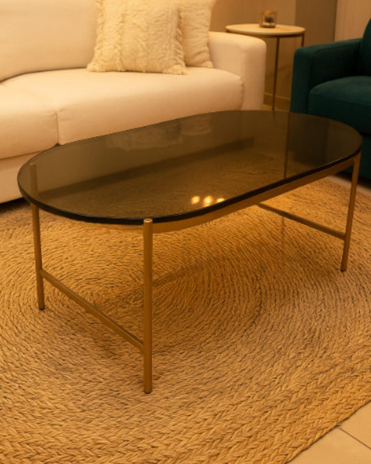 Mesa ratona de vidrio con detalles dorados de 90 x 50 cm en un living, en stock con entrega inmediata