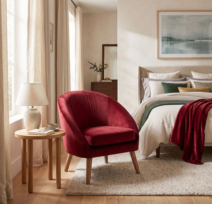 Sillón de un cuerpo Paris color Bordó en pana antimanchas importada, ambientado en un dormitorio junto a la cama y una mesa de luz — forma redonda y compacta con apoyabrazos integrados. Hecho a medida por Tienda de Banquitos.
