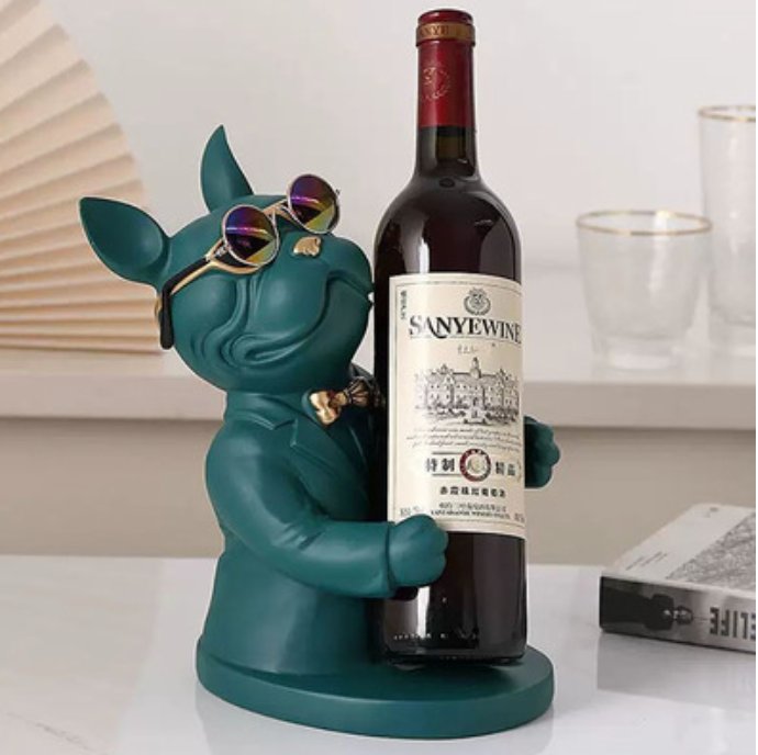 Bulldog francés verde petróleo mate con anteojos y moño dorado abrazando una botella de vino sobre base redonda