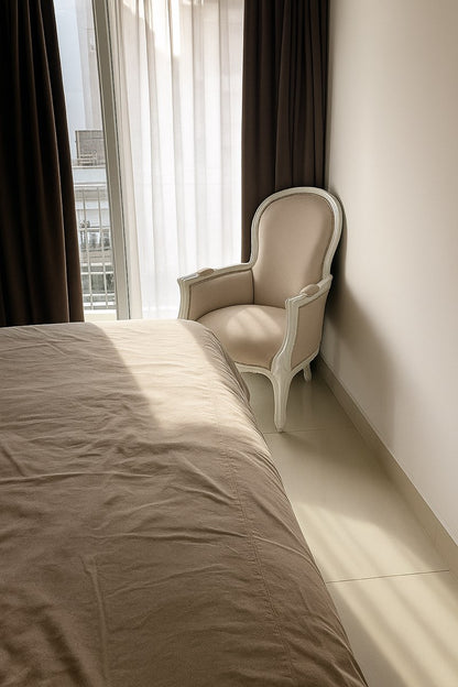 Detalle de la talla de madera blanca del sillón estilo Luis XV fabricado a medida