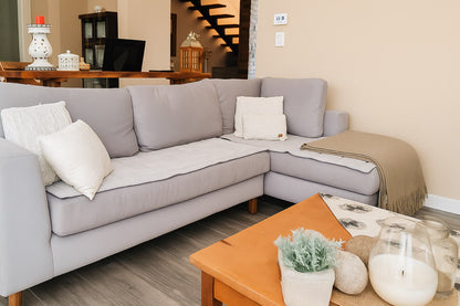 Sofá esquinero Bélgica en gris claro, diseño nórdico minimalista en L, en el living de Valeria