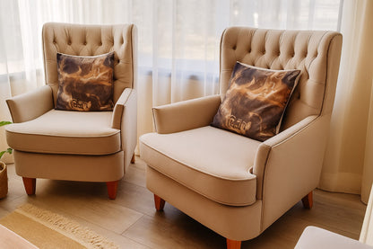 Dos sillones Esmeralda en beige, con capitoné en diamante y tachas en el marco, junto a un ventanal