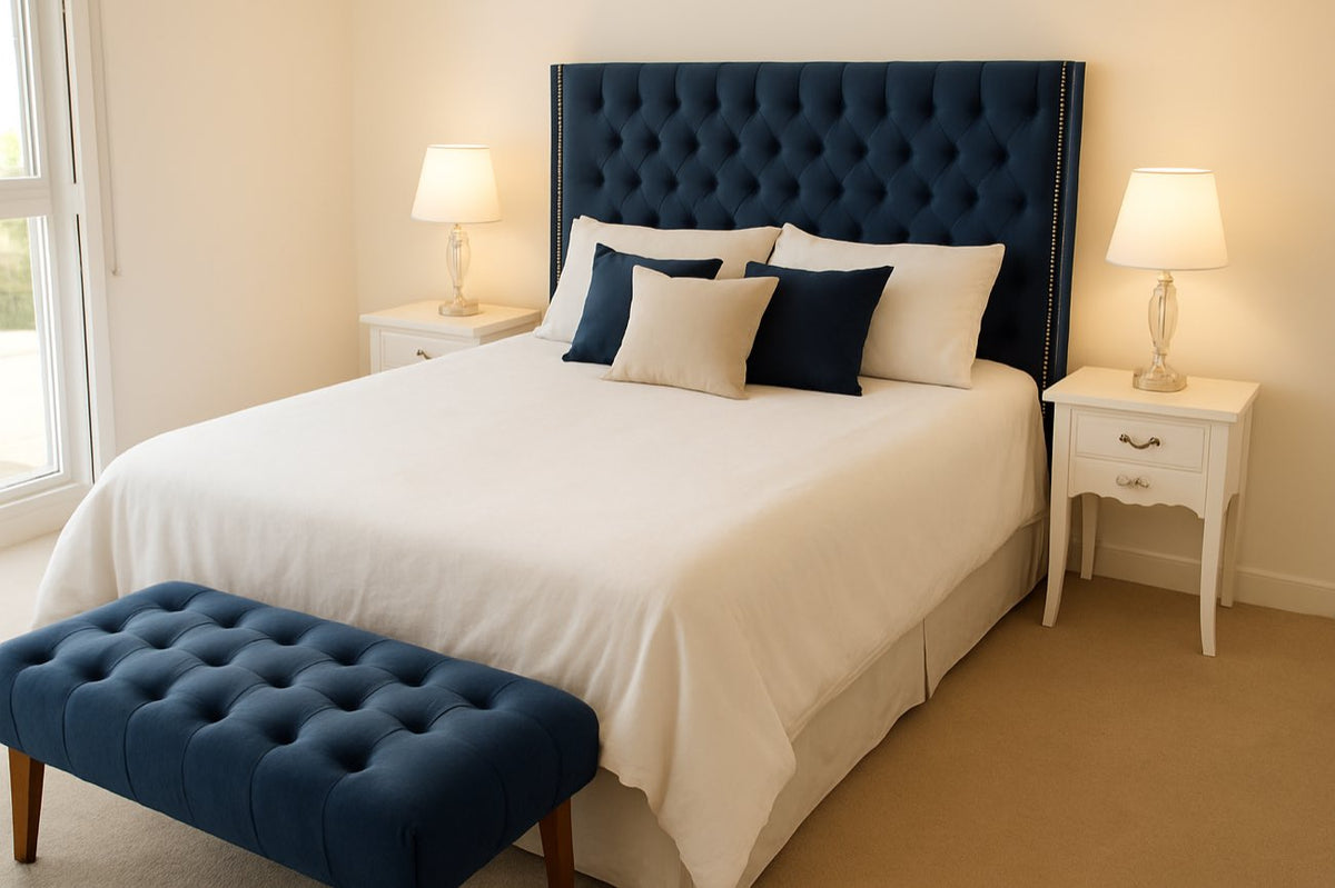 Respaldo de cama Emmy tapizado en azul ocean con capitoné en diamante y tachas plateadas en los bordes, junto a la banqueta pie de cama haciendo juego, en el dormitorio de Lu.