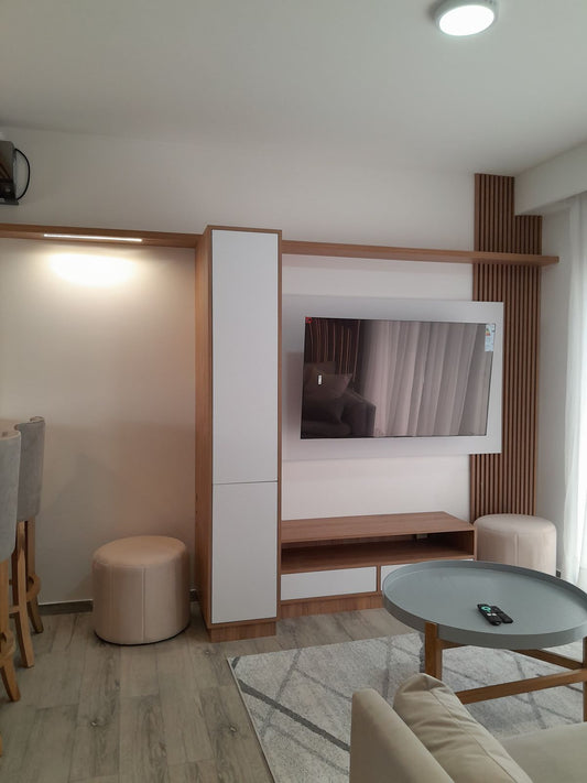 Puffs redondos tapizados a medida junto al mueble de TV, en el living diseñado por Arquitectura SN