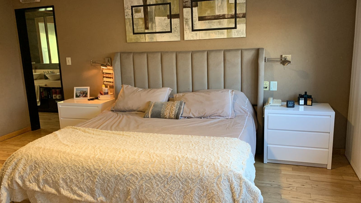 Respaldo Alpes gris con canales verticales y orejas, en la cama de Camila entre dos mesas de luz blancas