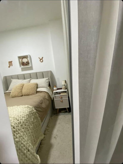 Dormitorio de Luli visto desde la puerta, con el Respaldo Alpes gris y los cuadros de signos zodiacales