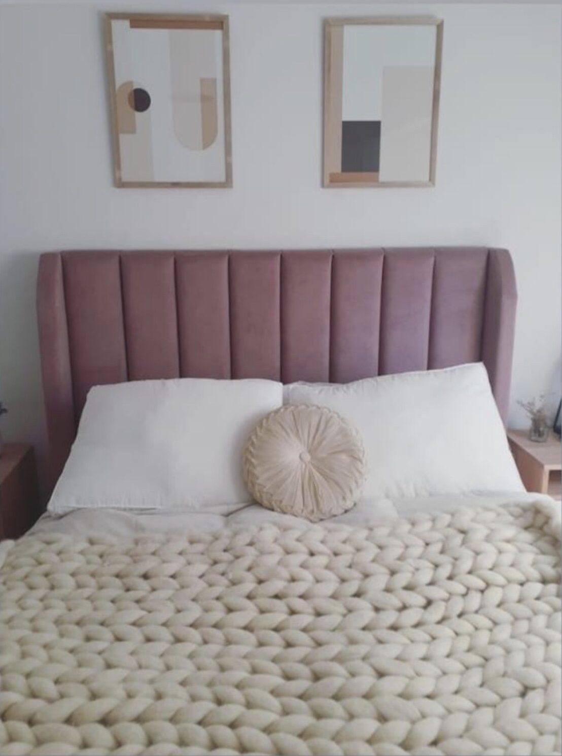 Respaldo Alpes rosa malva con canales verticales y orejas laterales, con ropa de cama blanca y manta tejida, en el dormitorio de Celeste