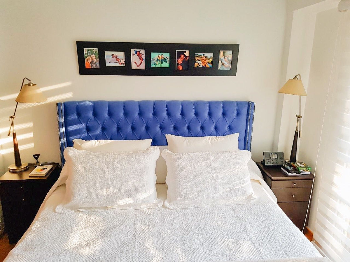 Respaldo Emmy azul con capitoné y aletas laterales en el dormitorio de Nerina
