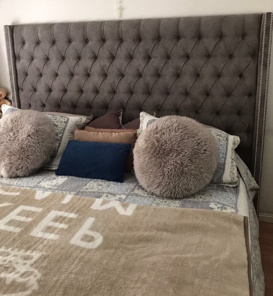 Respaldo Emmy gris con aletas laterales y almohadones de pelo, en el dormitorio de Sol